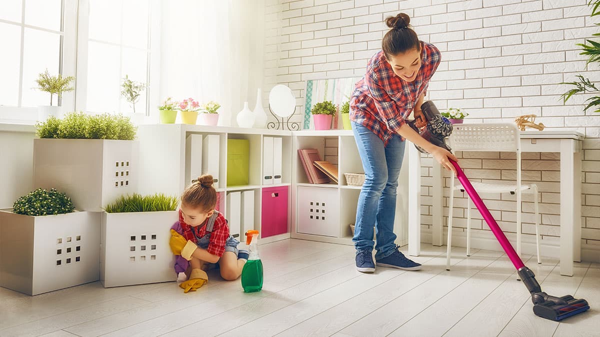 Mother and child cleaning a living room as part of a weekly cleaning routine for a busy Redmond WA home.